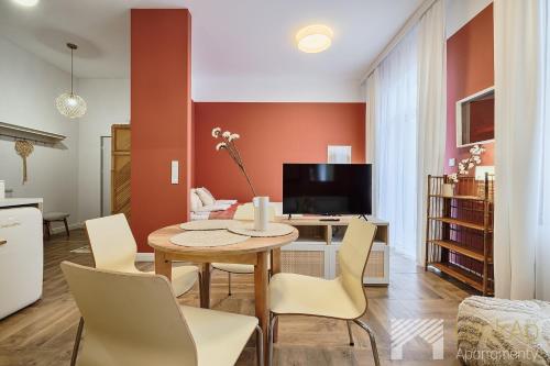 a kitchen and living room with a table and chairs at Kolorova Apart by LookAp - darmowy parking w centrum Łodzi! in Łódź