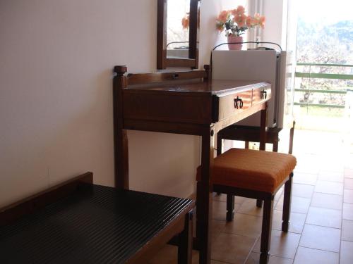 a wooden desk with a chair and a mirror at Hotel Inomaos in Olympia