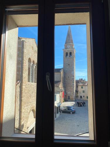 a window view of a city with a clock tower at Delizioso Attico Calle Lunga 2 in Grado