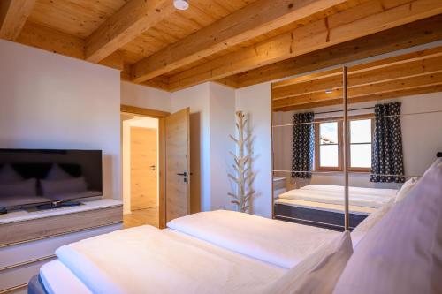 a bedroom with two beds and a flat screen tv at Chalet Dahoam in Garmisch-Partenkirchen