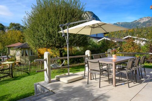 a table and chairs with an umbrella on a patio at Chalet Dahoam in Garmisch-Partenkirchen