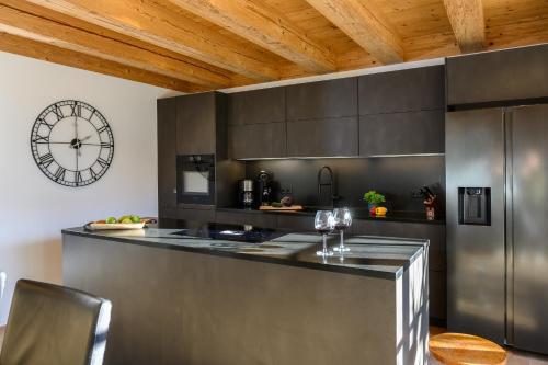 a kitchen with a large clock on the wall at Chalet Dahoam in Garmisch-Partenkirchen