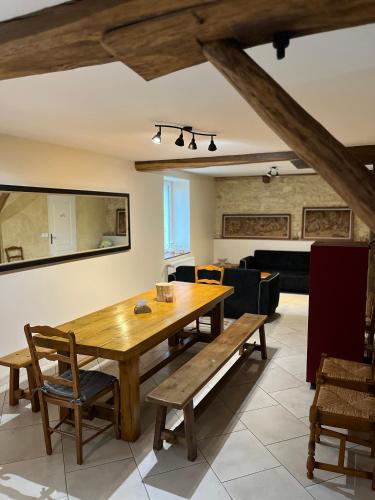 une salle à manger avec une table et des bancs en bois dans l'établissement La Fauconnière, à Brécy