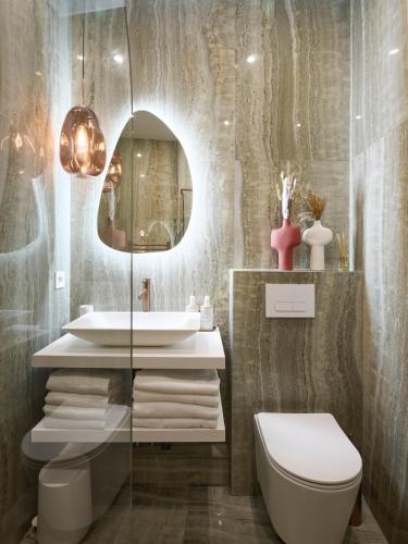 a bathroom with a sink and a toilet and a mirror at Le XV Cannes in Cannes