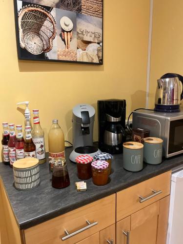 Una encimera de cocina con una cafetera y otros ingredientes. en La Fauconnière, en Brécy