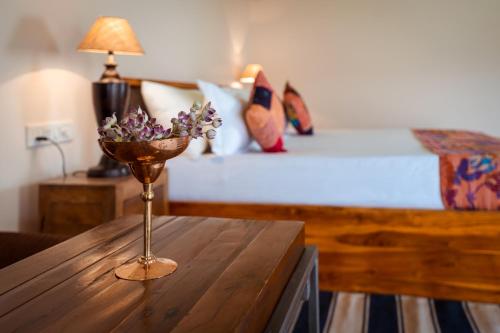 a table with a vase of flowers on top of a bed at Desert Vista Camp Jaisalmer in Jaisalmer