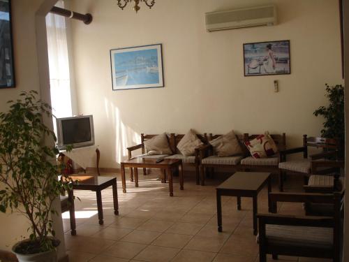 a living room with couches and tables and a tv at Hotel Inomaos in Olympia