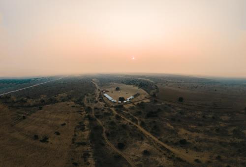 an aerial view of a field with the sunset in the background at Desert Vista Camp Jaisalmer in Jaisalmer