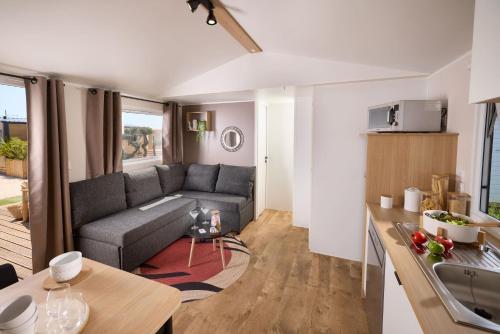 un salon avec un canapé et une table dans l'établissement CAMPING U SOMMALU, à Casaglione