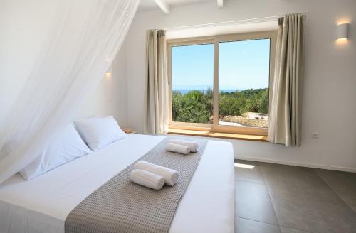a bedroom with a large white bed with towels on it at Villa Porto Mongonisi in Porto Ozias