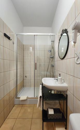 a bathroom with a shower and a sink and a mirror at Hostel Zamość - pokoje gościnne - bezpłatny parking in Zamość