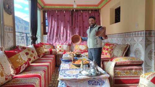 a man standing in a living room with a table at Dr ouanskra asni el haouz imlil in Imlil