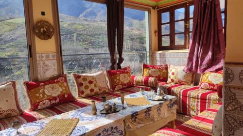 a living room with a couch and a large window at Dr ouanskra asni el haouz imlil in Imlil