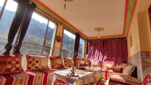 a room with a couch and a table and windows at Dr ouanskra asni el haouz imlil in Imlil