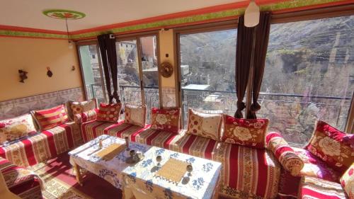 a living room with couches and a table and a window at Dr ouanskra asni el haouz imlil in Imlil