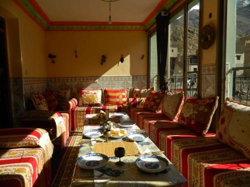 a living room with couches and a table with food at Dr ouanskra asni el haouz imlil in Imlil