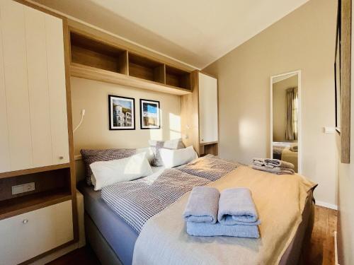 ein Schlafzimmer mit einem Bett mit Handtüchern darauf in der Unterkunft Ferienhaus Svantevit 31 Feriendorf Klein Stresow Rügen by ruyastay in Putbus