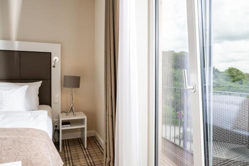 a hotel room with a bed and a balcony at Hotel Birke, Ringhotel Kiel in Kiel