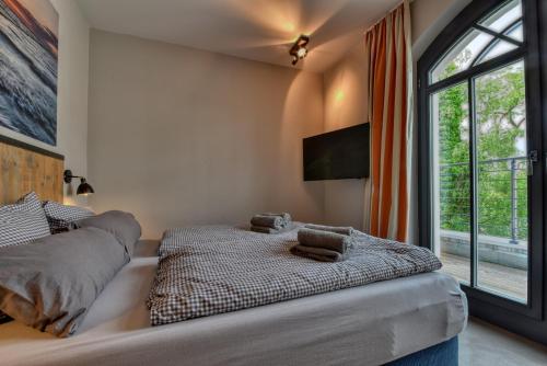 ビンツにあるFerienwohnung Treibholz in der Villa Martha Binzのベッドと大きな窓のある寝室