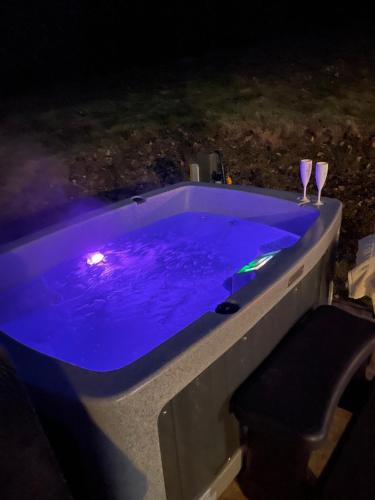 a swimming pool at night with two wine glasses at The Retreat, own hot tub, romantic escape, near Lyme Regis in Lyme Regis