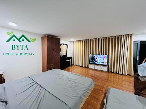 a bedroom with a bed and a tv in it at Byta House Homestay in Kinh Dinh
