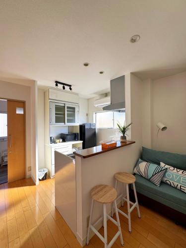 a kitchen and living room with a counter and stools at 全新装修南品川Haven有1间和室共2卧室 in Tokyo