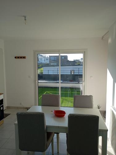 a dining room table with chairs and a bowl on it at Gîte à 400m de la mer in Ploudalmézeau