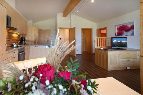 a large kitchen with a table with flowers on it at Gästehaus Trixl in Zell am See