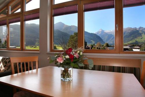 a vase of flowers sitting on a table with windows at Gästehaus Trixl in Zell am See