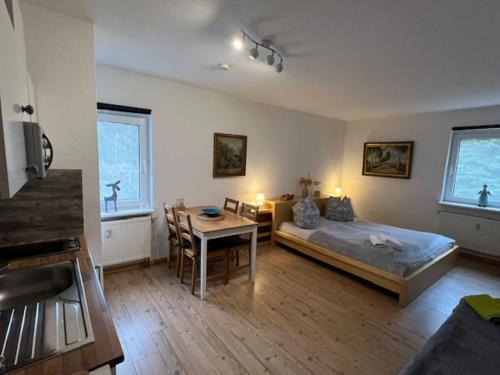 a bedroom with a bed and a table and a dining room at Ferienappartements am See in Schorfheide