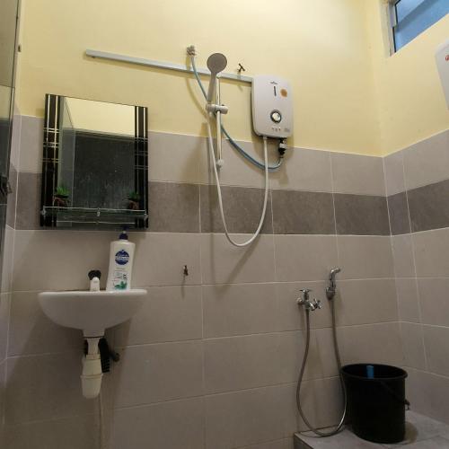 ein Badezimmer mit Dusche und Waschbecken in der Unterkunft Homestay Cikgu CT in Muadzam Shah