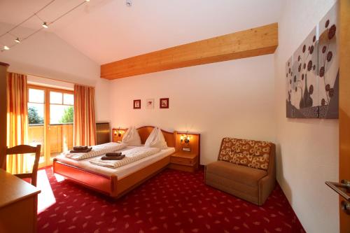 a hotel room with a bed and a chair at Gästehaus Trixl in Zell am See