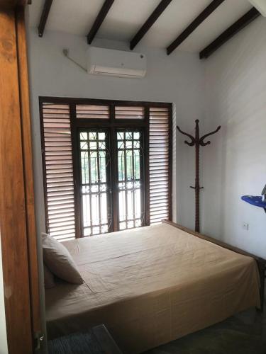 a bedroom with a bed and a cross on the wall at Beverly Edge Villa in Sri Jayewardenepura Kotte