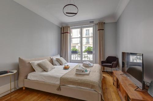 un salon avec un lit et une télévision dans l'établissement 682 Suite Blériot - Superbe Appartement à Paris, à Paris