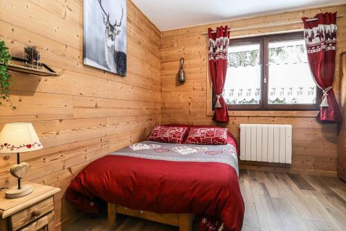 a bedroom with a bed in a wooden wall at L'Eden - T1 in Châtel