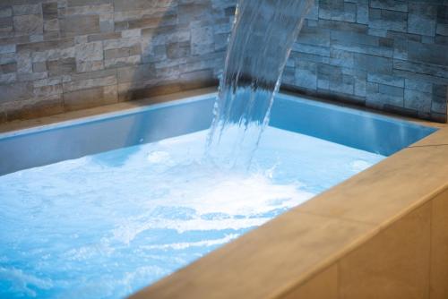 a water fountain in a swimming pool at Villa Redi Relaxing Spa in Piraeus