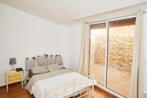 une chambre blanche avec un lit et une fenêtre dans l'établissement Maison village T5, à Fitou