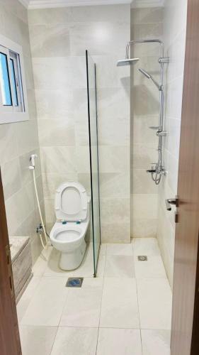 a bathroom with a toilet and a shower at فندق اوتادالمتحدة الذهبي الروضة 4 in Al Khansāk