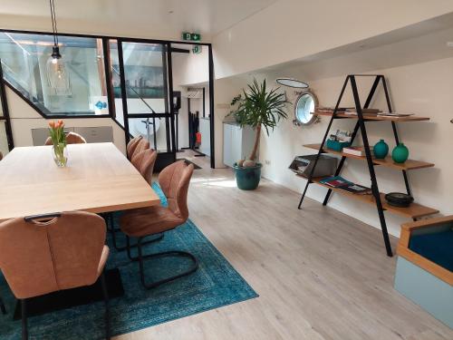 a dining room with a table and chairs in a room at Boat Rooms on Water hele schip in Rotterdam