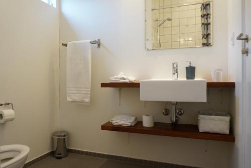 a bathroom with a white sink and a toilet at Lunds Hotel in Bogense