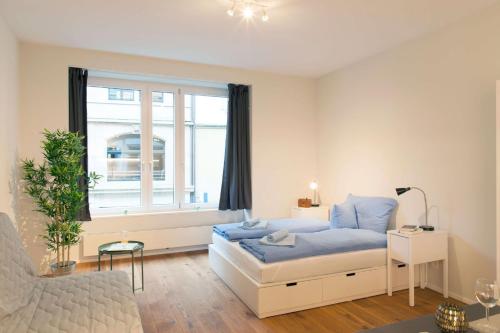 a bedroom with a bed and a window at HITrental Town Hall Apartments in Basel