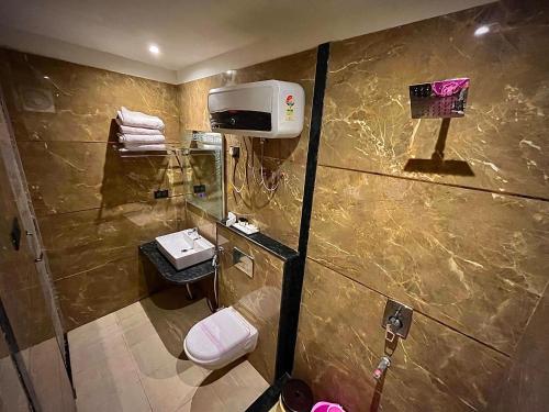 a bathroom with a shower and a toilet and a sink at Hotel Lata Continental in Kānpur