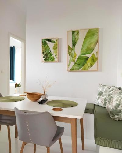 a white dining room with a table and chairs at ZEN Minimal Luxury Housing Tyros in Tiros