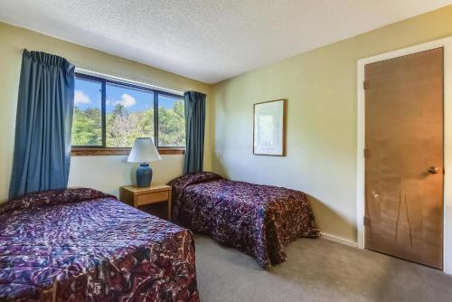 a bedroom with two beds and a window at Pinnacle F21 in Killington