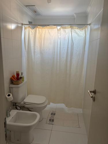 a white bathroom with a toilet and a shower at Alba II - Departamento 2 ambientes in Posadas