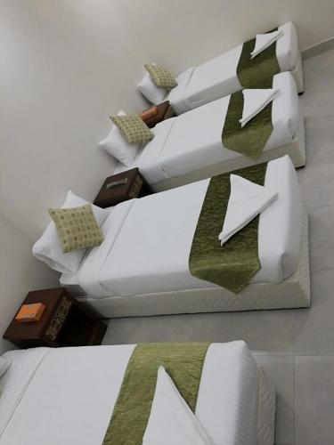 a room with two white couches with green ties at فندق اوتادالمتحدة الذهبي الروضة 4 in Al Khansāk