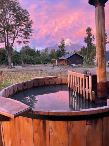 a small pond in a wooden fence with a sunset at Casa peumayen in Puerto Varas