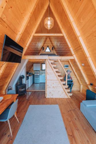 a cabin with a staircase in the middle of a room at A Frame Cabin - Valea Vinului in Vişeu de Mijloc