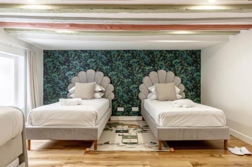 - 2 lits dans une chambre avec une fresque murale dans l'établissement Sweett - Casanova, à Paris