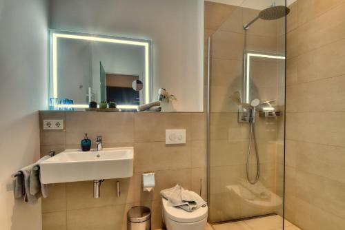 a bathroom with a shower and a sink and a toilet at Ferienwohnung Mauersegler 14 im Wreecher Idyll Rügen by ruyastay in Putbus